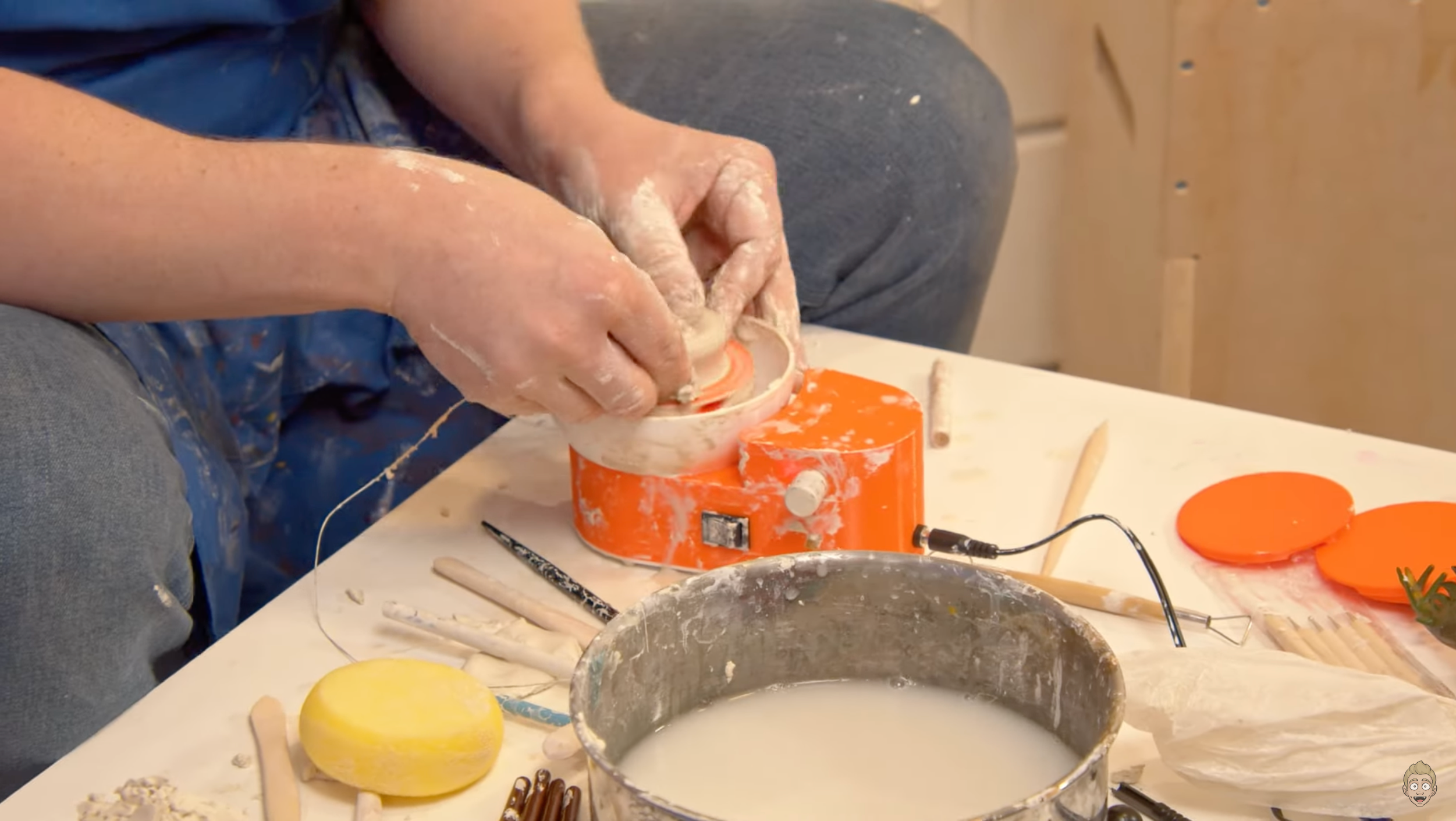 Load video: man using a miniature pottery wheel